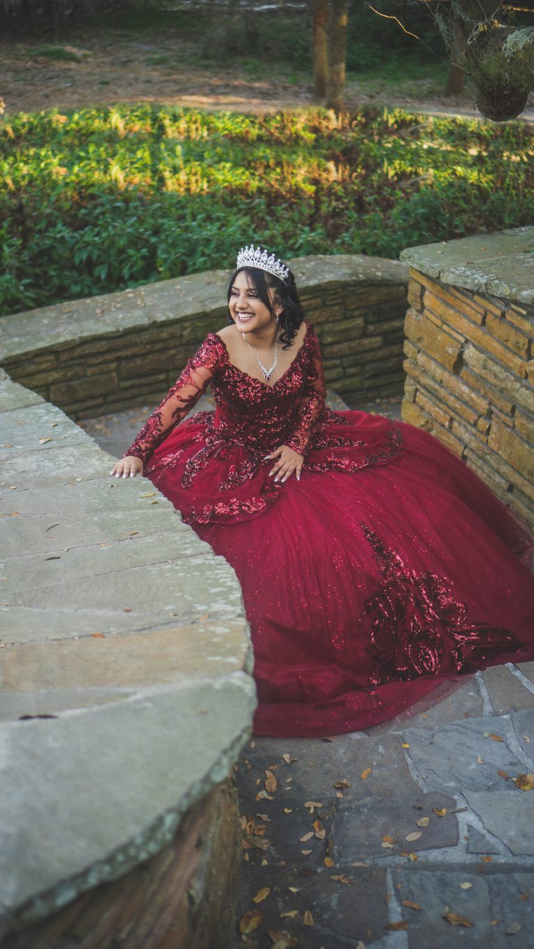 Portrait of a woman in a red gown on stone steps