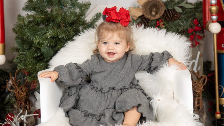 Holiday mini session portrait of a toddler in a festive studio set